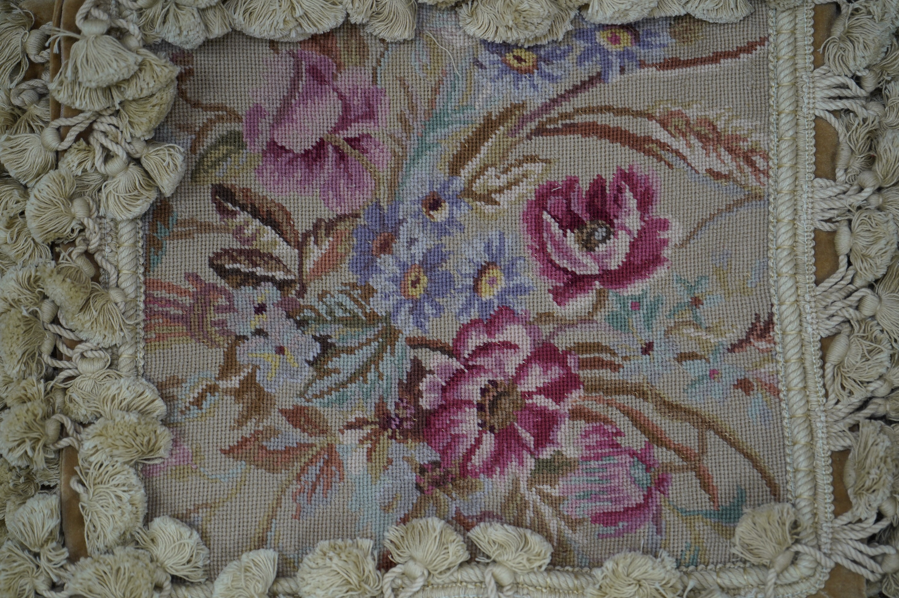 Four rectangular pink roses patterned wool worked cushions, all with mushroom tasselling, largest 46cm wide, 34cm high. Condition - good